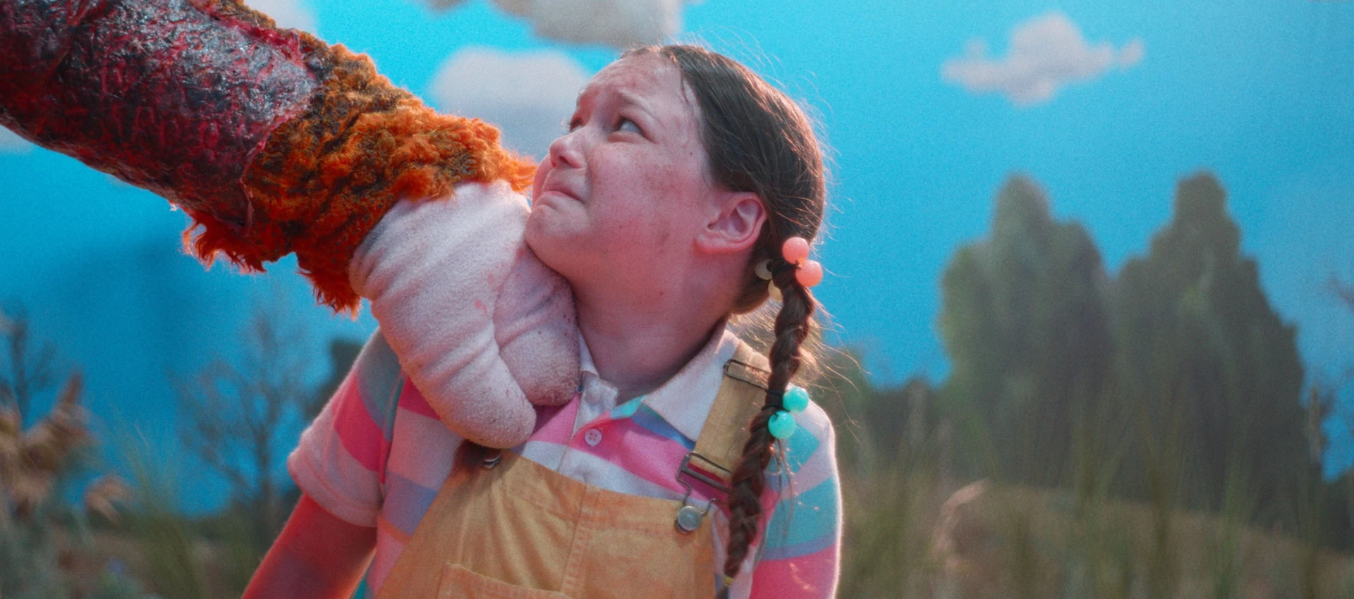 Delaney Quinn in Buddy (2026), facing the orange unicorn inside the children’s television world
