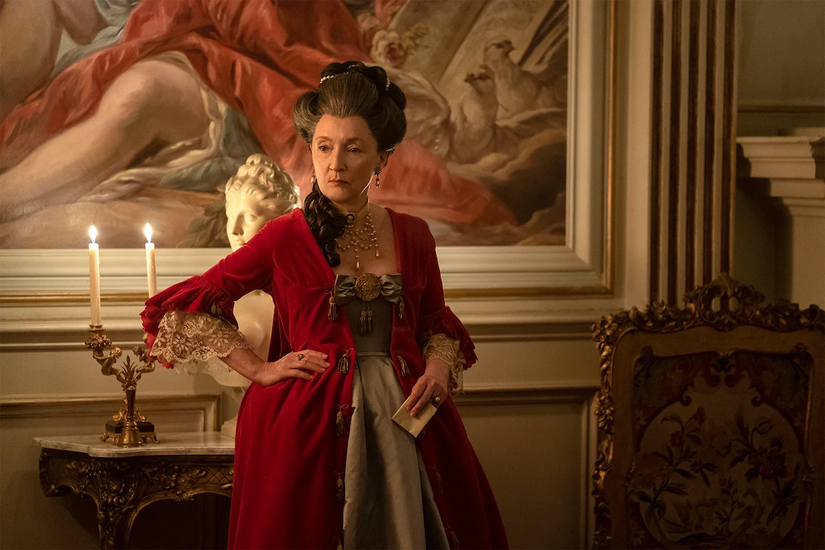 Alice Englert as Camille wearing a red gown in Dangerous Liaisons