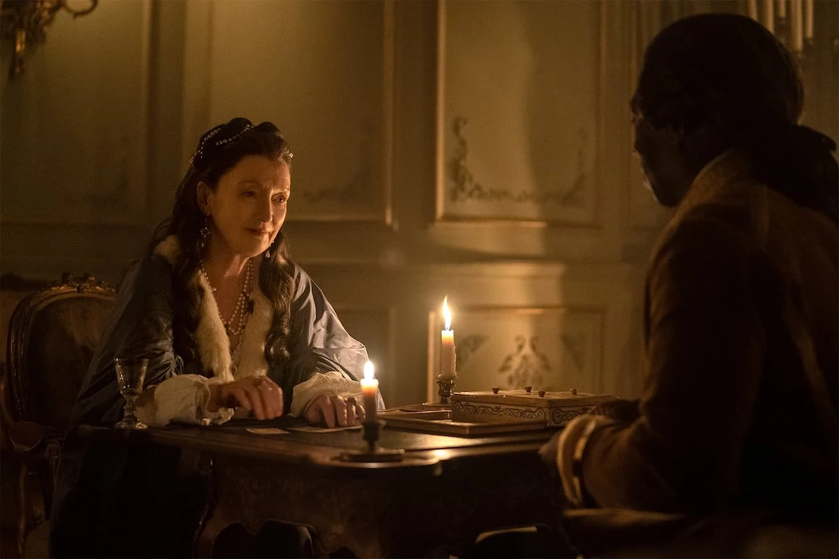 Lesley Manville as Madame de Merteuil at a candlelit table in Dangerous Liaisons