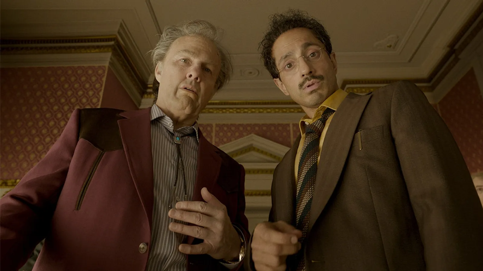 Riz Ahmed and John Goodman in an ornate interior in Digger (2026)