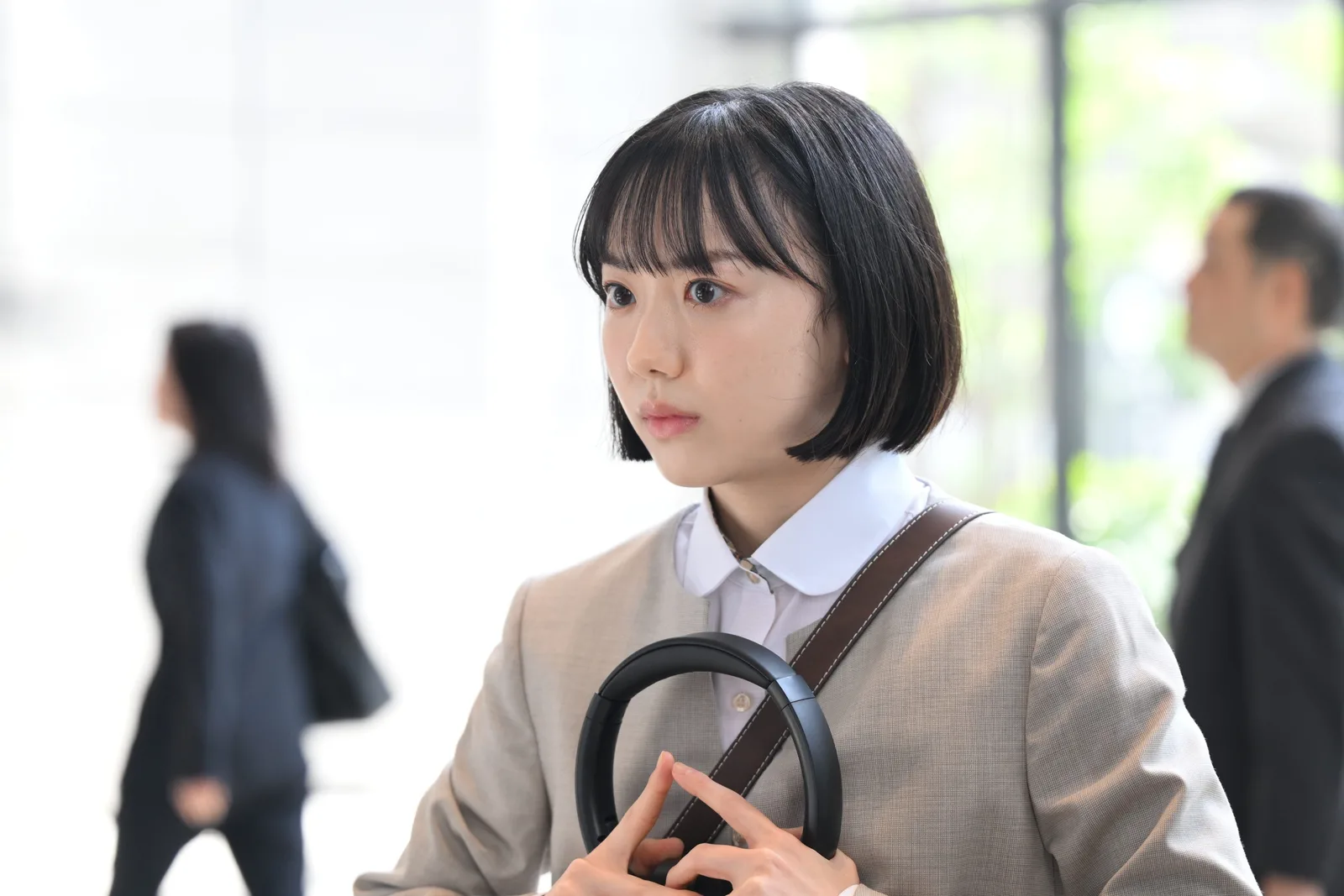 Extraordinary Attorney Minami Mana Ashida as Minami in headphones at the law office