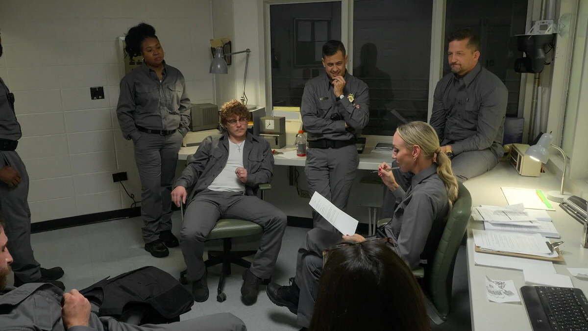 Participants in guard uniforms discussing events in The New Stanford Prison Experiment