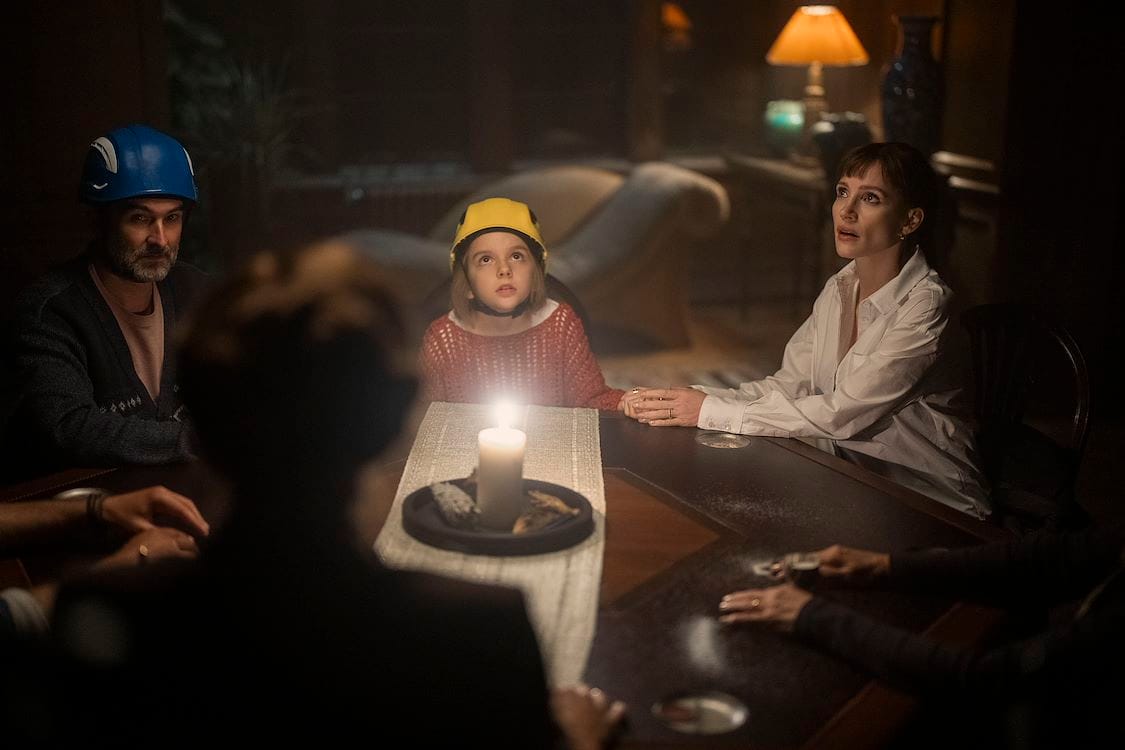 Bela and Ursula at a candlelit family gathering in Other Mommy (2026)